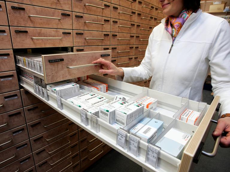 Eine Apothekerin nimmt in Hannover am 17. Januar 2006 Medikamente aus der Schublade des Medikamentenschranks.