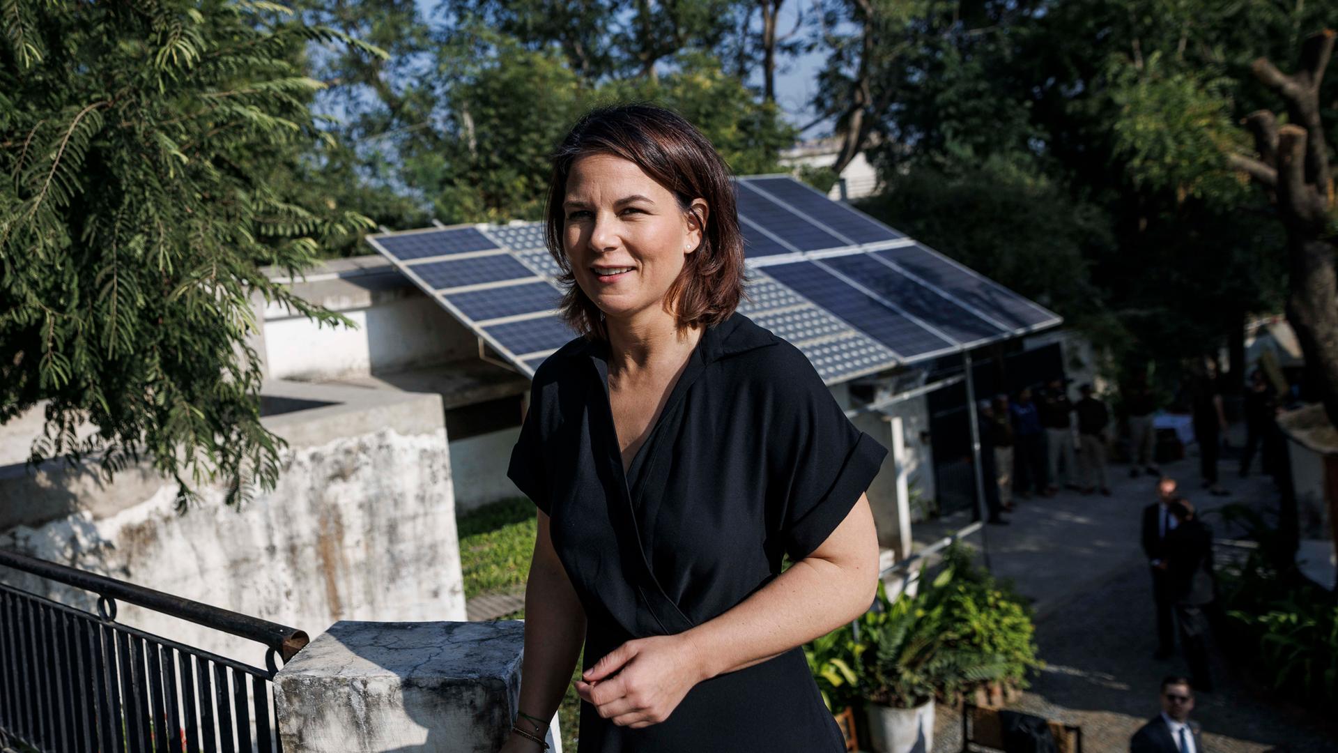 Annalena Baerbock (Bündnis 90/ Die Grünen), Bundesaußenministerin, steht vor einem Solardach des Projektes "Social Center for Rural Initiative and Advancement". In einem indischen Dorf werden Projekte zu regenerativen Energien und Regenwasserspeicherung umgesetzt. 