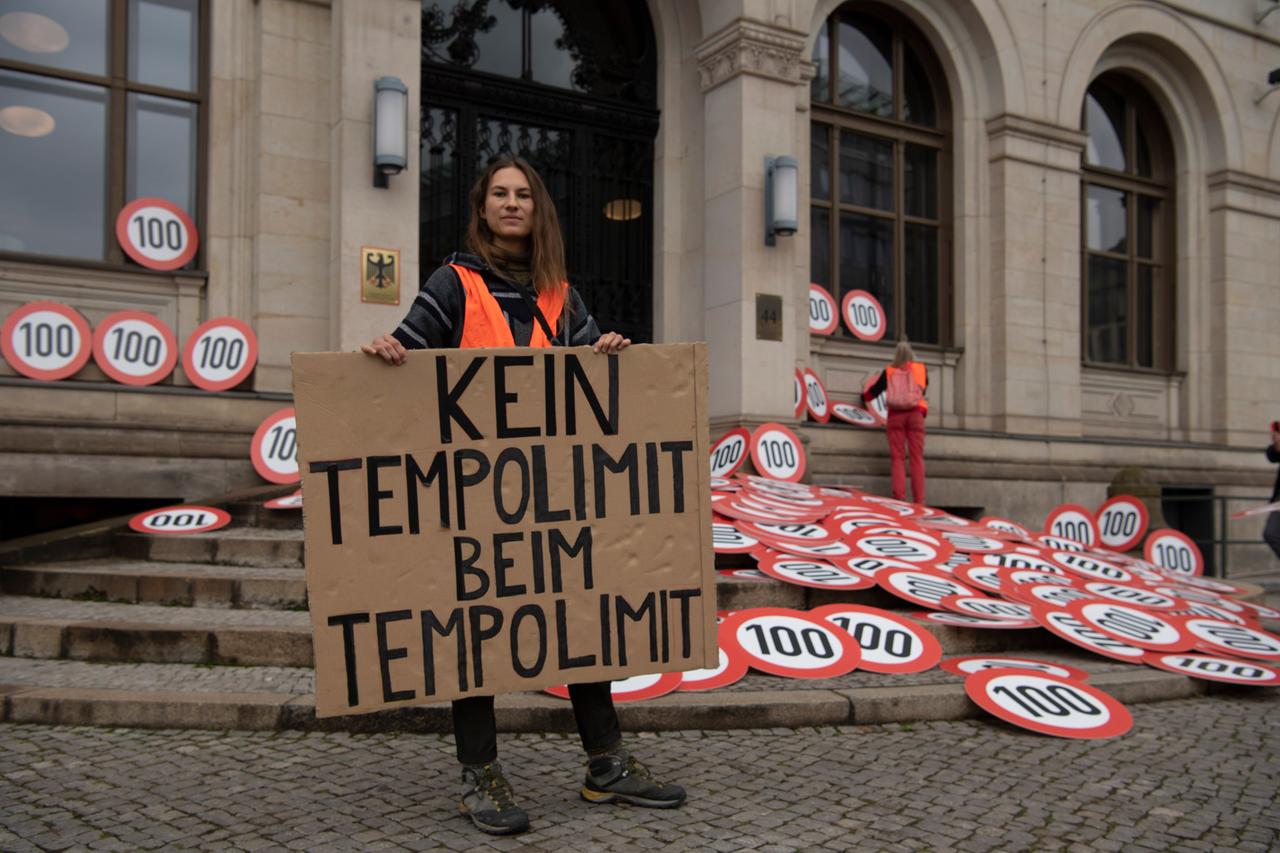 Ein Mitglied der Klimaschutz-Protestgruppe "Letzte Generation" steht mit einem Schild mit der Aufschrift "Kein Tempolimit beim Tempolimit" vor dem Bundesverkehrsministerium, wo die Gruppe 500 Tempo-100-Schilder ablegt. Mit der Aktion wollen die Aktivisten erreichen, dass umgehend eine Geschwindigkeitsbeschränkung auf bundesdeutschen Autobahnen eingerichtet wird, um die CO2-Belastung deutlich zu verringern. Ein Mitglied der Klimaschutz-Protestgruppe "Letzte Generation" steht mit einem Schild mit der Aufschrift "Kein Tempolimit beim Tempolimit" vor dem Bundesverkehrsministerium, wo die Gruppe 500 Tempo-100-Schilder ablegt. Mit der Aktion wollen die Aktivisten erreichen, dass umgehend eine Geschwindigkeitsbeschränkung auf bundesdeutschen Autobahnen eingerichtet wird, um die CO2-Belastung deutlich zu verringern.