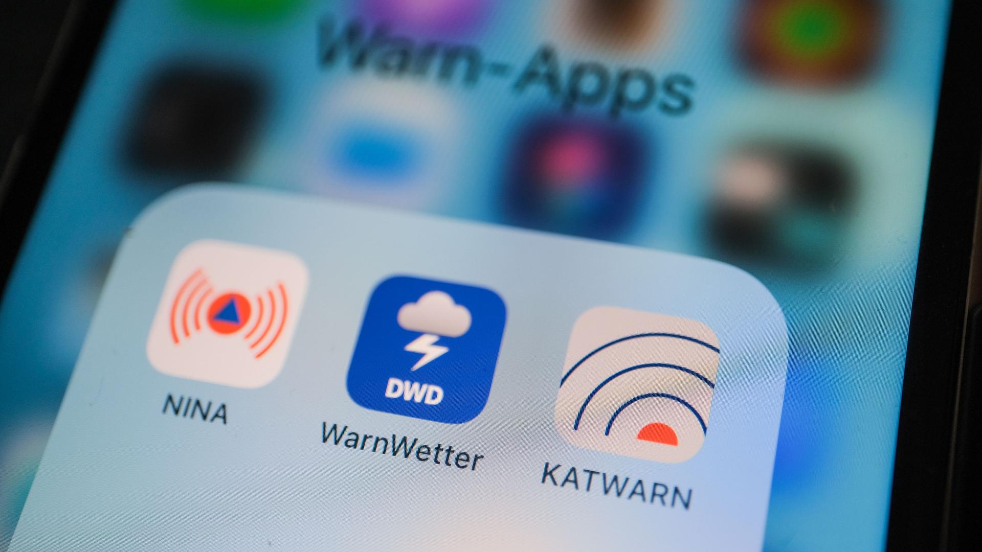 Die NINA Warn-App, das WarnWetter vom DWD und die Katwamrn-App sind auf einem Handy-Bildschirm zu sehen. 