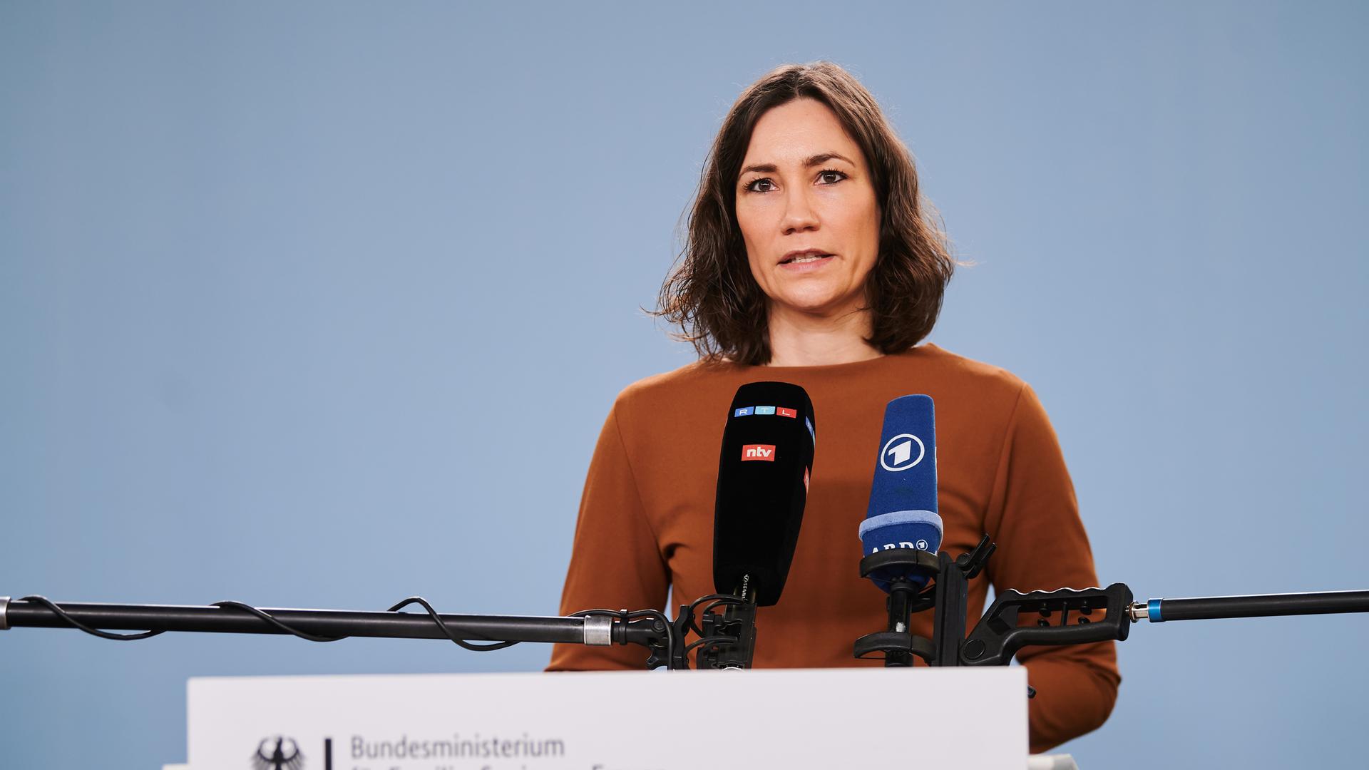 Bundesfamilienministerin Anne Spiegel steht an einem Rednerpult mit Mikrofonen von RTL/ntv und ARD. Bundesfamilienministerin Anne Spiegel steht an einem Rednerpult mit Mikrofonen von RTL/ntv und ARD.