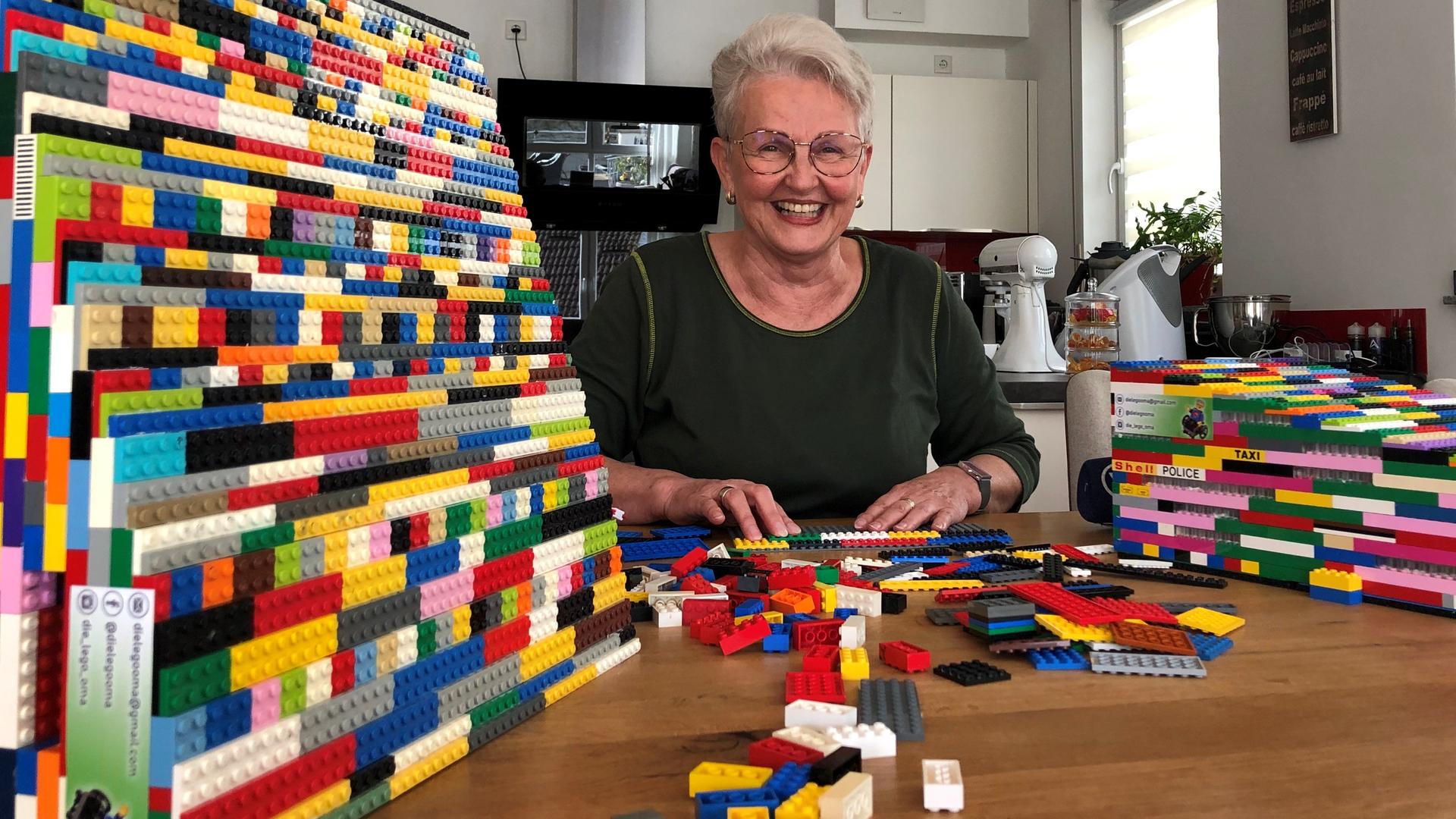 Die Lego-Oma Rita Ebel aus Hanau sitzt in ihrer Küche, neben ihr eine Rollstuhlrampen aus Legosteinen. Die Lego-Oma Rita Ebel aus Hanau sitzt in ihrer Küche, neben ihr eine Rollstuhlrampen aus Legosteinen.