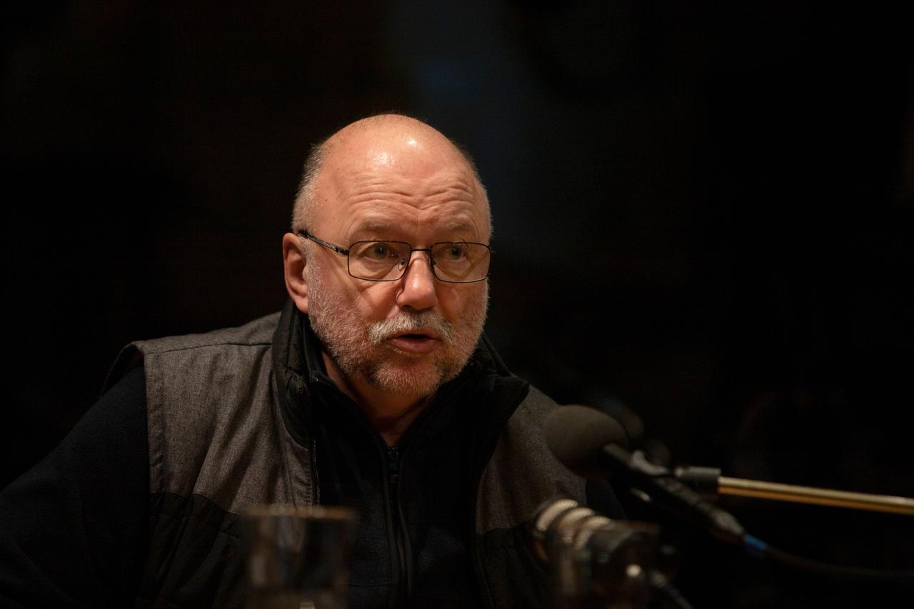 Andrej Kurkow auf einer Bühne, hinter einem Mikrofon Andrej Kurkow auf einer Bühne, hinter einem Mikrofon