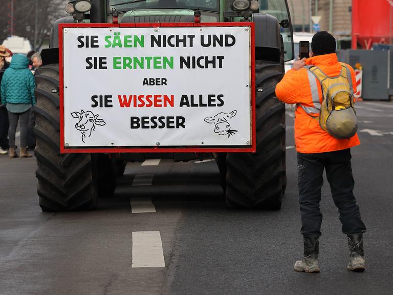 Bauernproteste: Landwirte aus zahlreichen Bundesländern Deutschlands protestieren mit ihren Traktoren in der Hauptstadt. Auf einem Plakat steht: "Sie säen nicht und sie ernten nicht, aber sie wissen alles besser."
