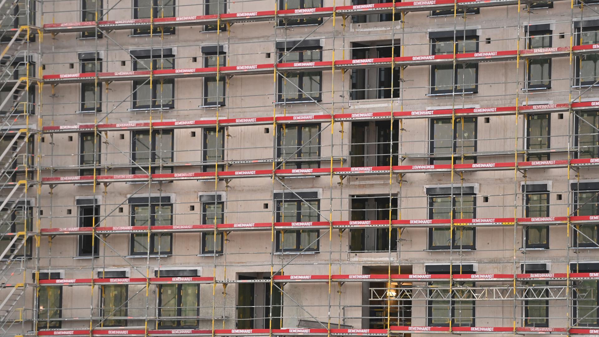 Blick auf ein im Bau befindliches großes Mietshaus mit eingerüsteter Fassade. Blick auf ein im Bau befindliches großes Mietshaus mit eingerüsteter Fassade.