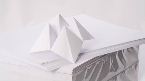 Aus Papier gebasteltes Spielzeug auf einem Stapel weißen Druckerpapieres.