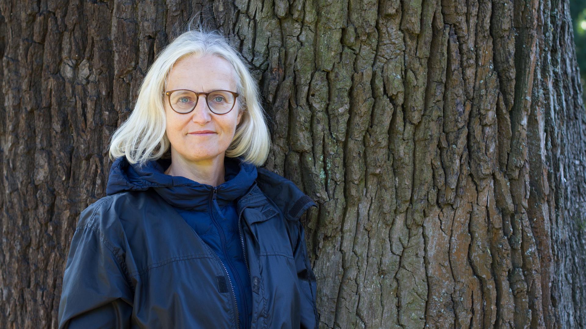 Christiane Hoffmann lehnt an einem Baum.