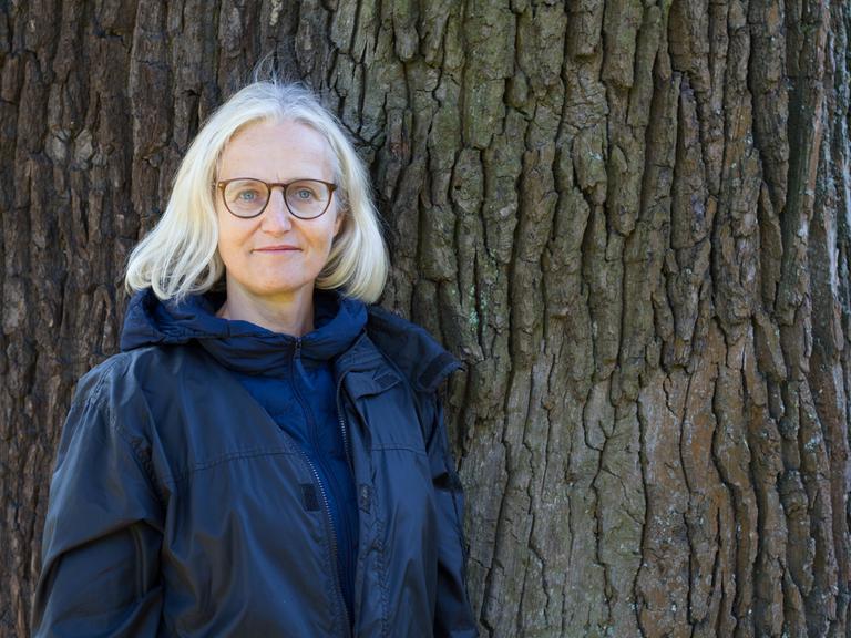Christiane Hoffmann lehnt an einem Baum.