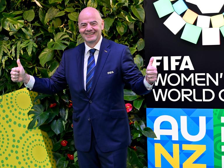 FIFA-Präsident Giovanni Infantino zeigt vor dem Logo der Frauen-WM in Australien und Neuseeland beide Daumen hoch.
