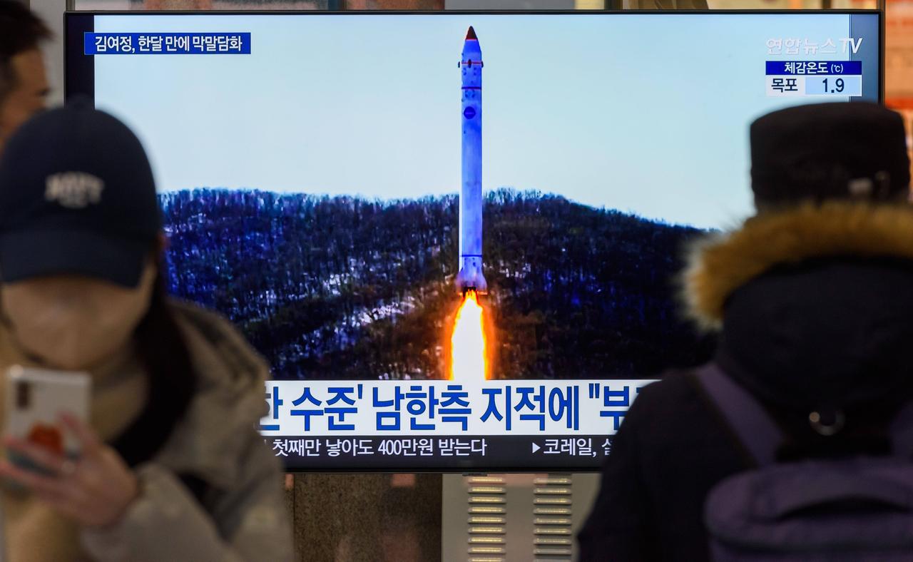 Ein Fernsehbildschirm zeigt am 20.12.2022 das Bild einer nordkoreanischen Rakete mit Testsatelliten während einer Nachrichtensendung