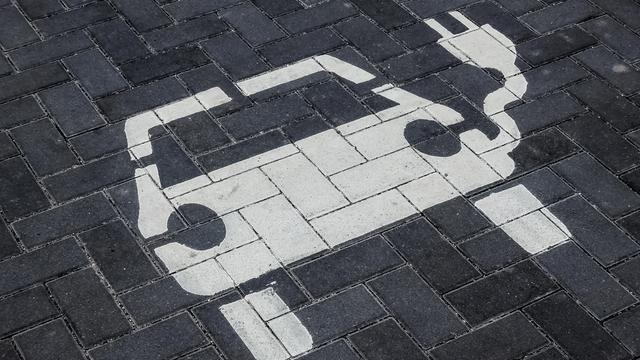 Ein Parkplatz für Elektroautos. Auf die Pflastersteine ist in Weiß ein Elektrofahrzeug mit Ladekabel gemalt.