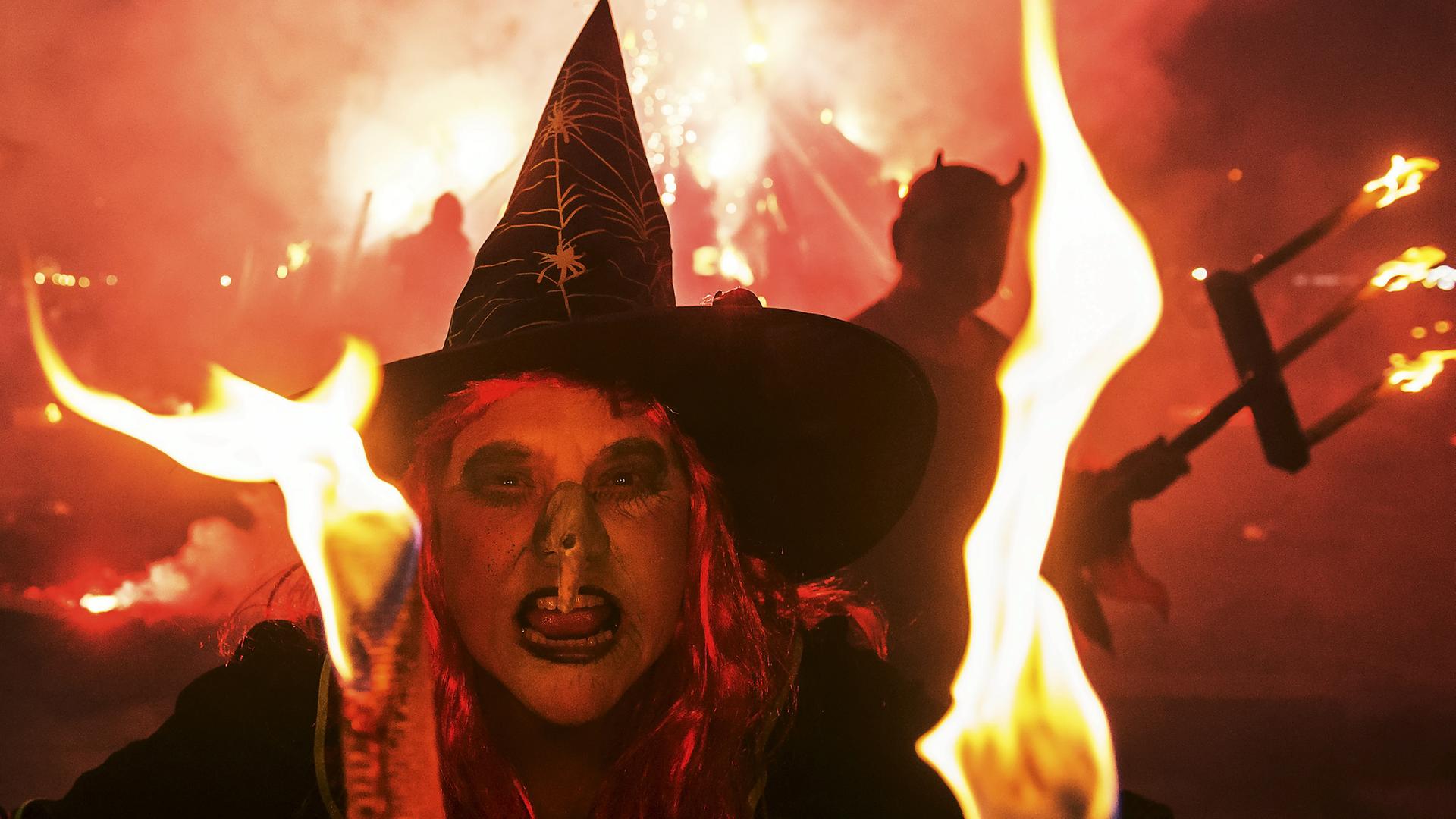 Als Teufel (rechts) und Hexe (Mitte) verkleidete Menschen in der Walpurgis-Nacht. Als Teufel (rechts) und Hexe (Mitte) verkleidete Menschen in der Walpurgis-Nacht.