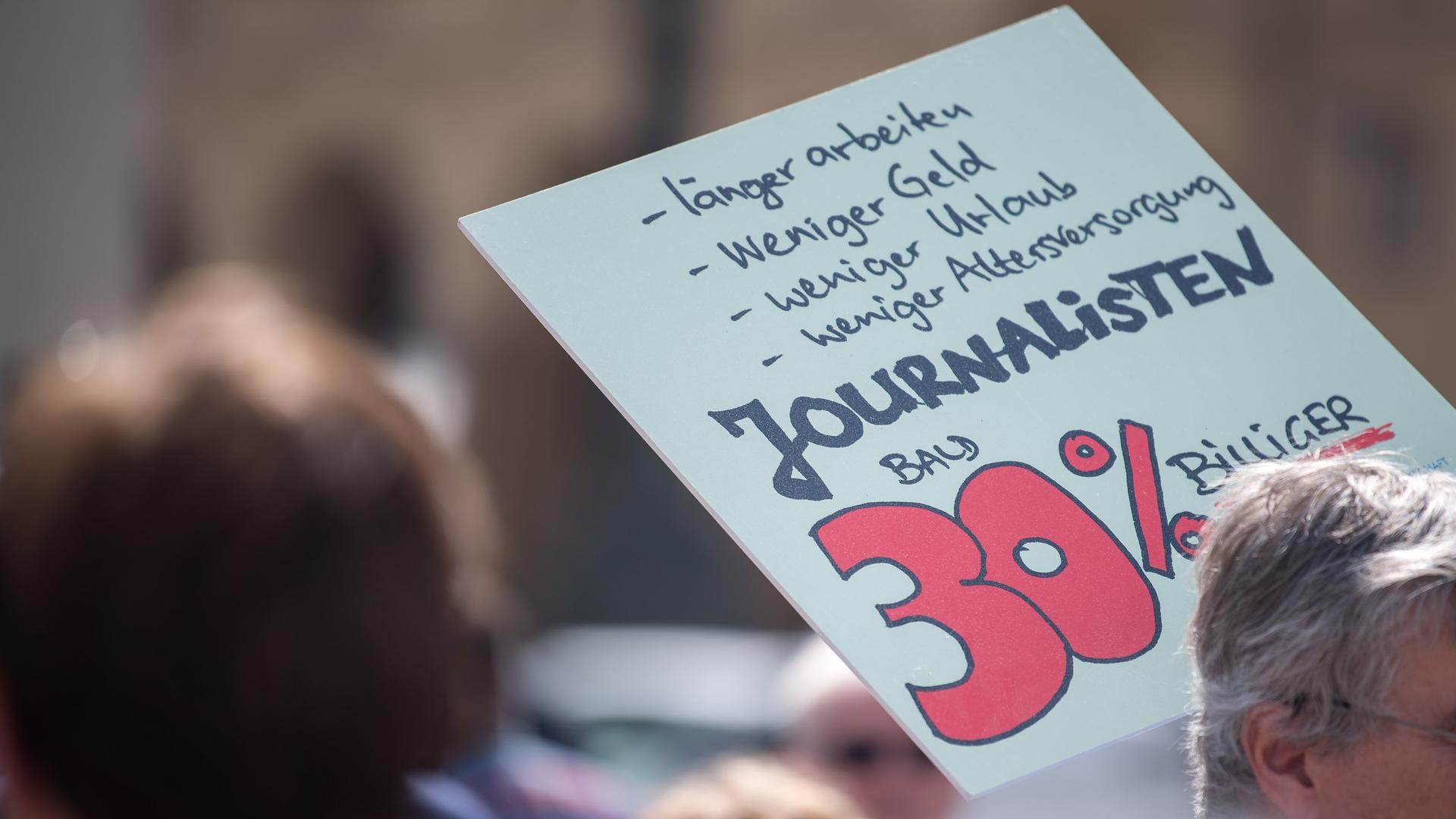Mit einem Plakat mit der Aufschrift "Journalisten bald 30% billiger" nimmt ein Journalist an einer Demonstration in der Münchener Innenstadt teil. Mit einem Plakat mit der Aufschrift "Journalisten bald 30% billiger" nimmt ein Journalist an einer Demonstration in der Münchener Innenstadt teil.