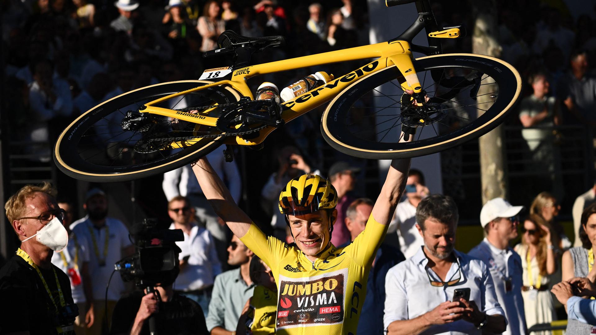 Der dänische Radprofi Jonas Vingegaard hält nach seinem Sieg bei der 109. Tour de France sein Fahrrad in die Höhe. Der dänische Radprofi Jonas Vingegaard hält nach seinem Sieg bei der 109. Tour de France sein Fahrrad in die Höhe.