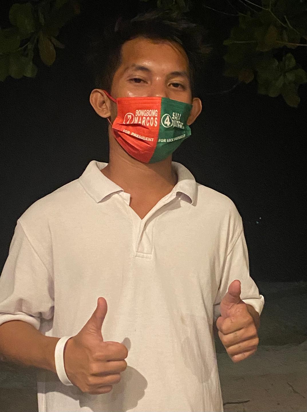 Ein Mann mit rot-grünem Mundschutz reckt die Daumen in die Höhe. Rot steht für Marcos junior, grün für Sara Duterte Ein Mann mit rot-grünem Mundschutz reckt die Daumen in die Höhe. Rot steht für Marcos junior, grün für Sara Duterte