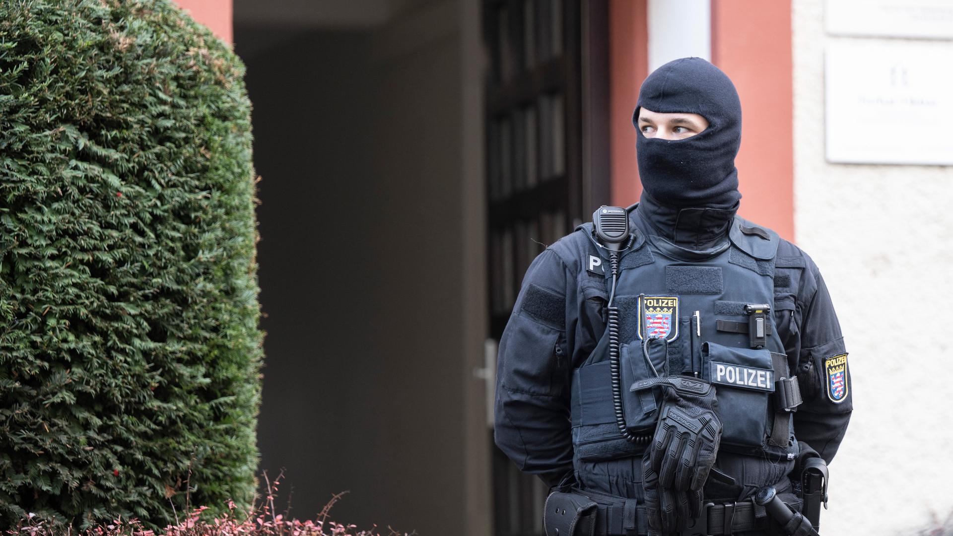 Bei einer Razzia gegen sogenannte Reichsbürger sichert ein Polizist ein durchsuchtes Objekt in Frankfurt