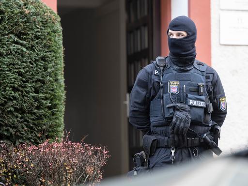 Bei einer Razzia gegen sogenannte Reichsbürger sichert ein Polizist ein durchsuchtes Objekt in Frankfurt