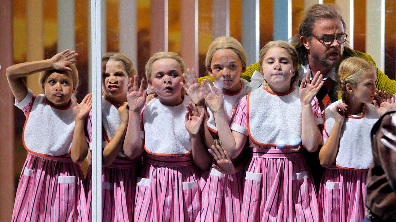 Mädchen drücken sich die Nase an einer Fensterscheibe platt, Foto aus "Rheingold" bei den Bayreuther Festspielen 2022. Mädchen drücken sich die Nase an einer Fensterscheibe platt, Foto aus "Rheingold" bei den Bayreuther Festspielen 2022.