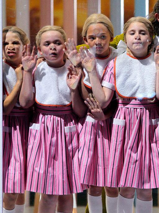 Mädchen drücken sich die Nase an einer Fensterscheibe platt, Foto aus "Rheingold" bei den Bayreuther Festspielen 2022.