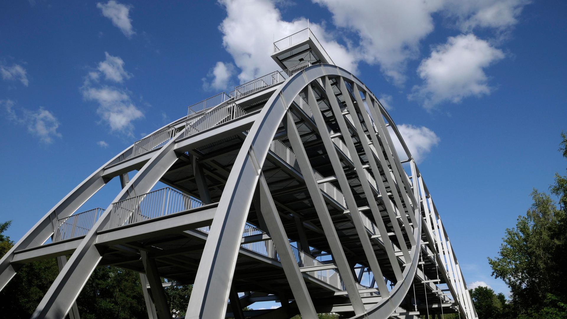 Auf dem Bitterfelder Berg erhebt sich eine schwungvolle stählerne Bogenkonstruktion, die an Brückenarchitektur erinnert Auf dem Bitterfelder Berg erhebt sich eine schwungvolle stählerne Bogenkonstruktion, die an Brückenarchitektur erinnert