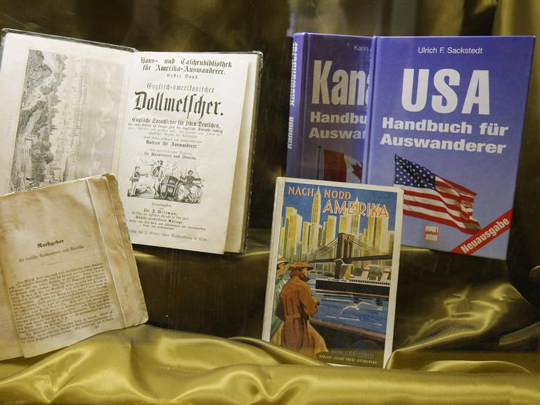 Ein Exponat zeigt Handbücher für Auswanderer nach Amerika aus verschiedenen Epochen im Auswanderermuseum BallinStadt in Hamburg.