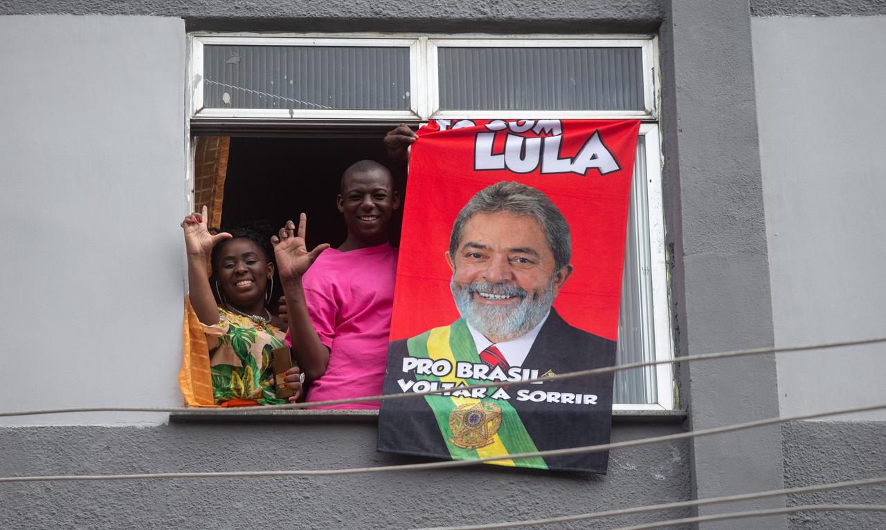 Anhänger des Präsidentschaftskandidaten der brasilianischen Arbeiterpartei (PT), Ex-Präsident Luiz Inácio Lula da Silva stehen am Fenster und machen machen mit ihren Händen den Buchstaben "L" in Anspielung auf seinen Namen. 