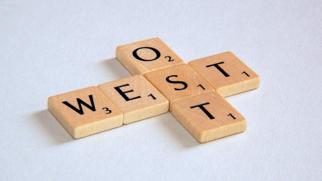 "Ost" und "West" - Schriftzug aus Scrabblesteinen.