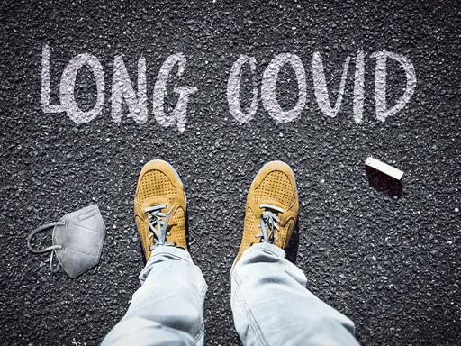 Person steht vor dem Schriftzug Long Covid