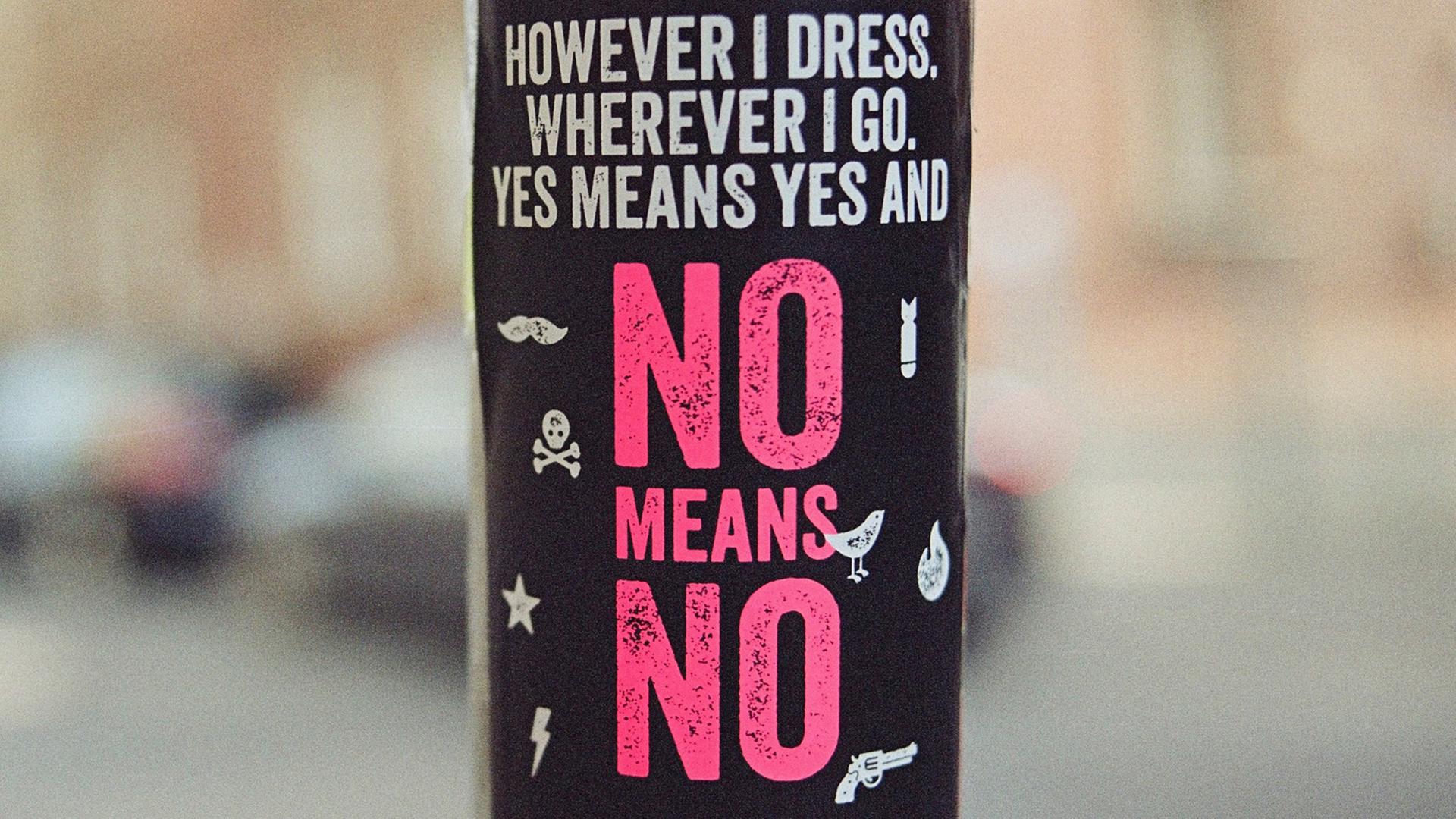 Eine rote Aufschrift auf schwarzem Hintergrund: However I dress, wherever I go, yes means yes and no means no. (Übersetzung: Wie immer ich mich kleide, wo immer ich gehe: Ja meint Ja und Nein meint Nein)
