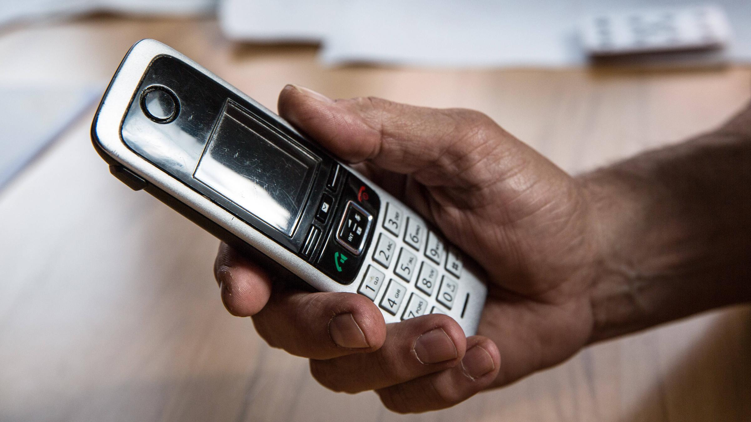 Die Hand eines älteren Menschen hält ein Telefon in der Hand. Vor allem Seniorinnen und Senioren werden Opfer von Telefonbetrug Die Hand eines älteren Menschen hält ein Telefon in der Hand. Vor allem Seniorinnen und Senioren werden Opfer von Telefonbetrug
