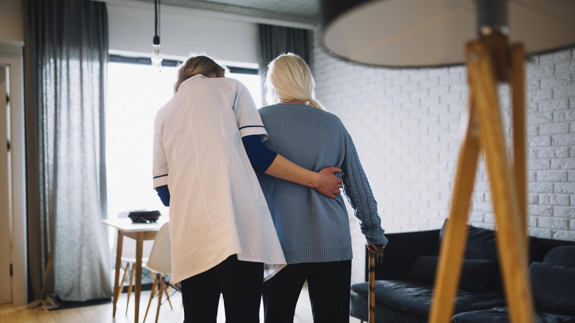 Eine Seniorin geht mit einer Krankenschwester in einem Altersheim. Eine Seniorin geht mit einer Krankenschwester in einem Altersheim.