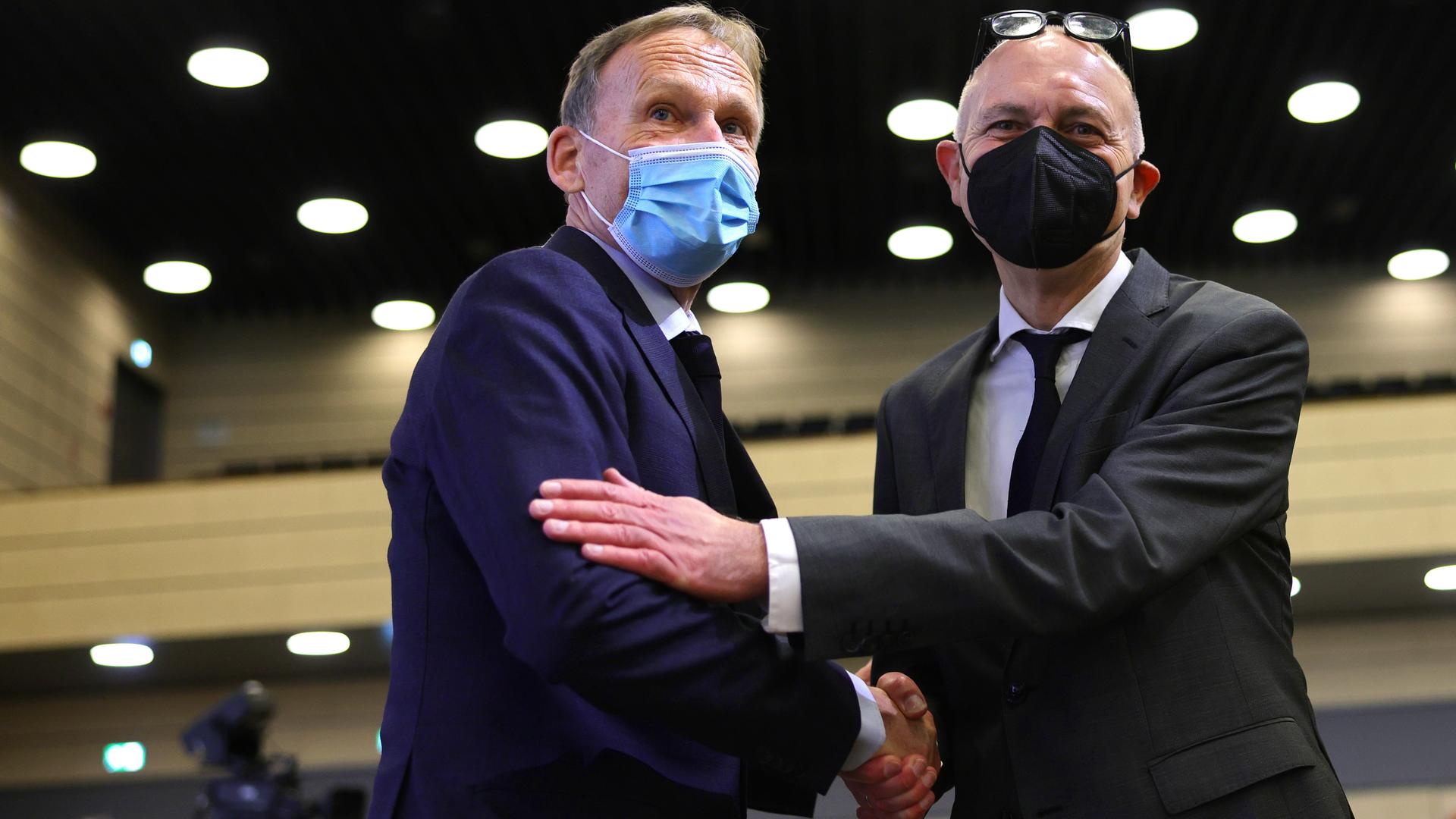 Hans-Joachim Watzke und Bernd Neuendorf schütteln sich die Hand, beide tragen einen Mund-Nasen-Schutz Hans-Joachim Watzke und Bernd Neuendorf schütteln sich die Hand, beide tragen einen Mund-Nasen-Schutz