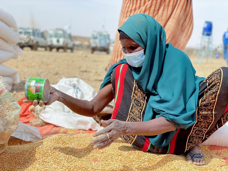 Eine äthioptische Frau sichtet die verteilten Lebensmittel