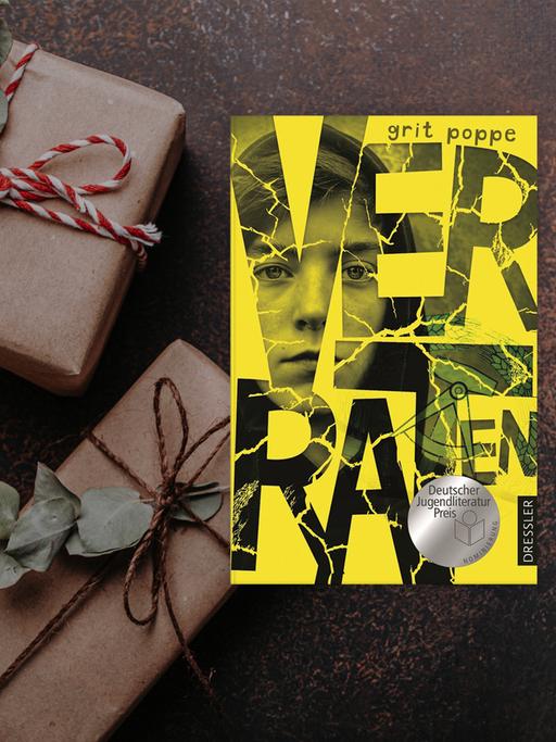 Cover des Buchs Verraten von Grit Poppe neben weihnachtlichen Päckchen.