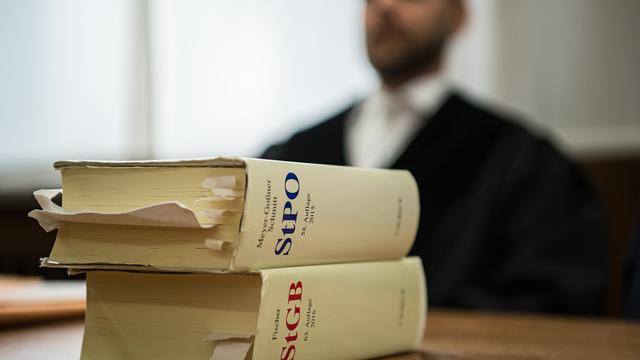 Vor einem Staatsanwalt liegen im Landgericht in Mönchengladbach (Nordrhein-Westfalen) die Strafprozessordnung und das Strafgesetzbuch