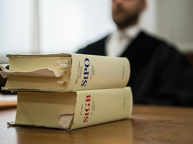 Vor einem Staatsanwalt liegen im Landgericht in Mönchengladbach (Nordrhein-Westfalen) die Strafprozessordnung und das Strafgesetzbuch