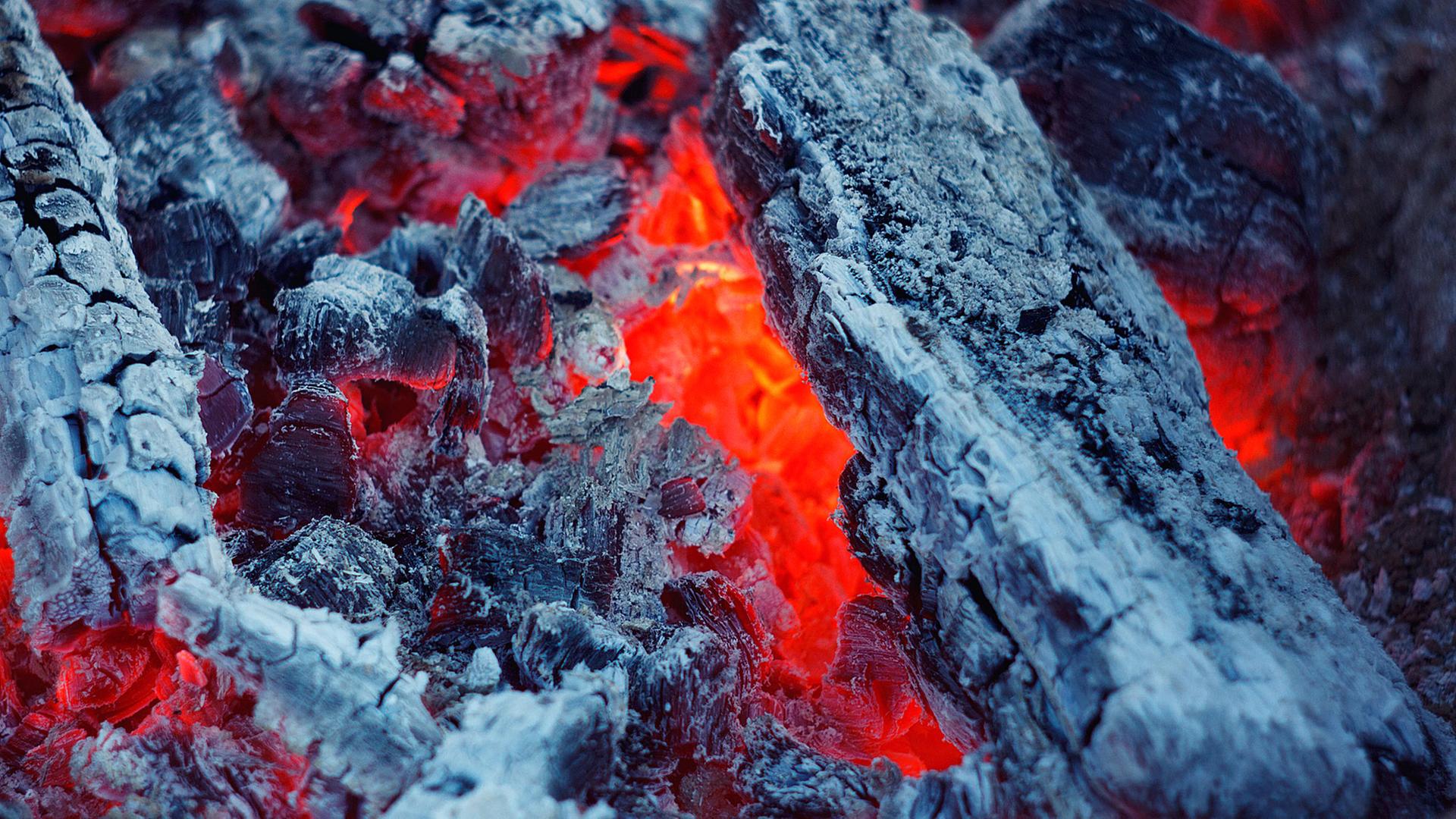 Zu sehen: Nahaufnahme eines Feuerst mit Glut und Asche. Zu sehen: Nahaufnahme eines Feuerst mit Glut und Asche.