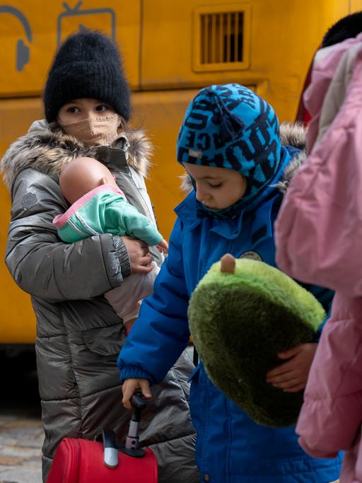 Kinder aus Odessa stehen nach ihrer Ankunft in Berlin vor einem Bus.