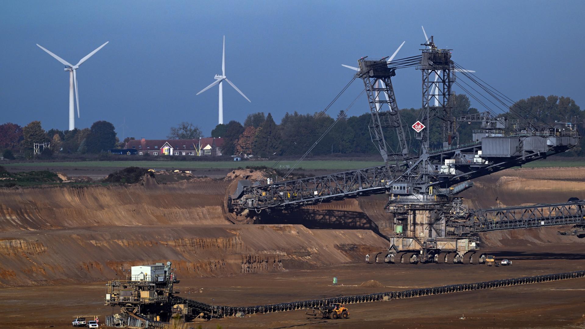 Ein Schaufelradbagger arbeitet im Braunkohletagebau Garzweiler. Im Hintergrund ist die Ortschaft Lützerath zu sehen. Ein Schaufelradbagger arbeitet im Braunkohletagebau Garzweiler. Im Hintergrund ist die Ortschaft Lützerath zu sehen.
