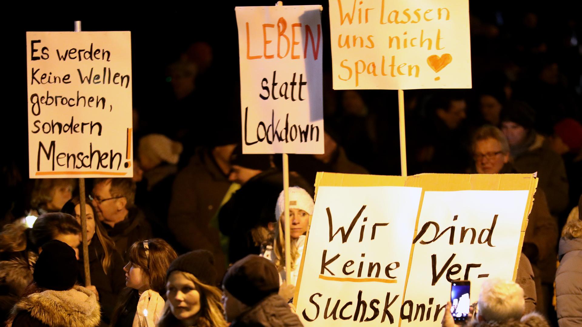 Demonstrationen halten Schilder mit Parolen gegen Corona-Einschränkungen Demonstrationen halten Schilder mit Parolen gegen Corona-Einschränkungen