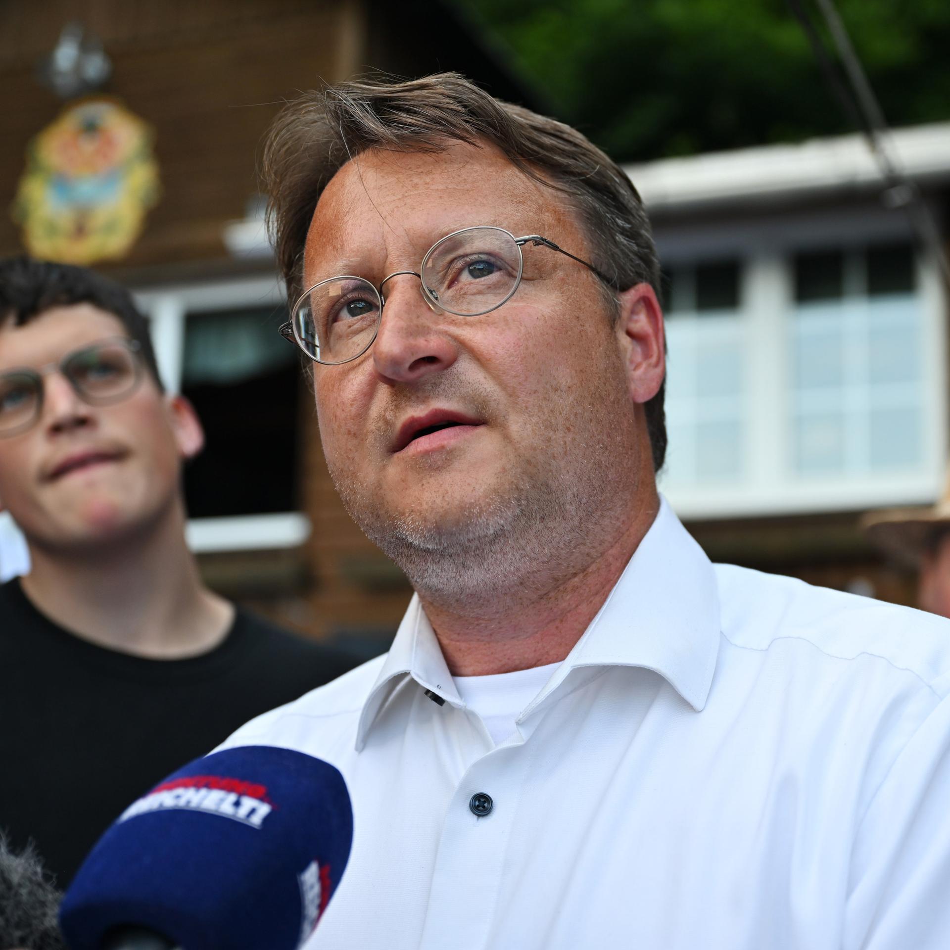 Der Wahlsieger des thüringischen Landkreises Sonneberg, Robert Stuhlmann (AfD), steht vor einem Mikrofon und blickt nach oben.