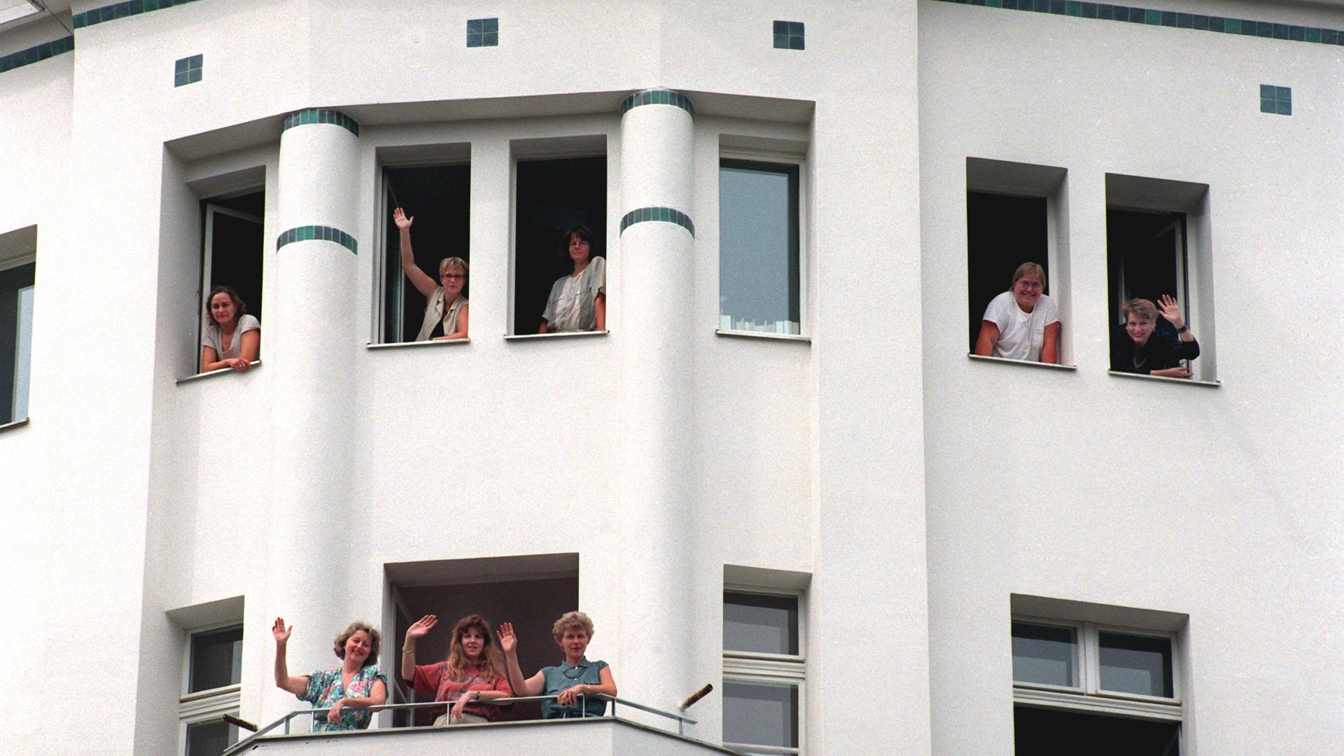 Unternehmerinnen winken im August 1995 aus einem frisch sanierten Gebäude des entstehenden Gewerbehofes der Frauengenossenschaft "WeiberWirtschaft" im Berliner Bezirk Mitte. 