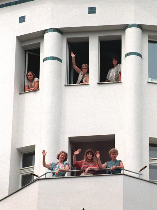 Unternehmerinnen winken im August 1995 aus einem frisch sanierten Gebäude des entstehenden Gewerbehofes der Frauengenossenschaft "WeiberWirtschaft" im Berliner Bezirk Mitte. 
