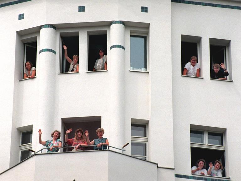 Unternehmerinnen winken im August 1995 aus einem frisch sanierten Gebäude des entstehenden Gewerbehofes der Frauengenossenschaft "WeiberWirtschaft" im Berliner Bezirk Mitte. 