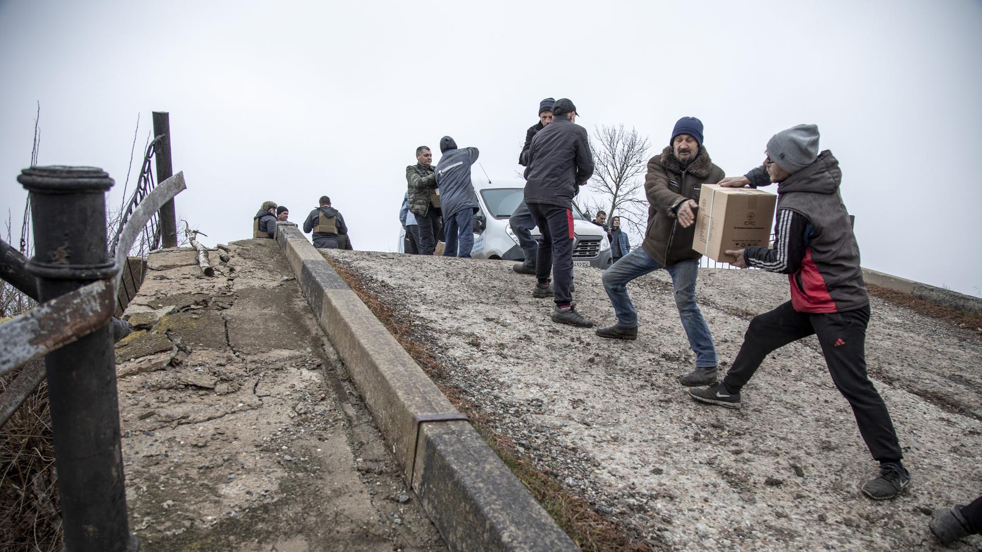 Transfer von Hilfspaketen über eine zerstörte Brücke in der Region Mykolajiw im Süden der Ukraine am 17.11.2022