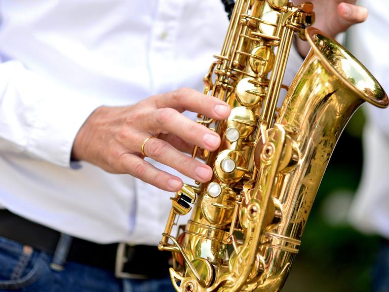 Ein Musiker spielt auf einem Saxophon.