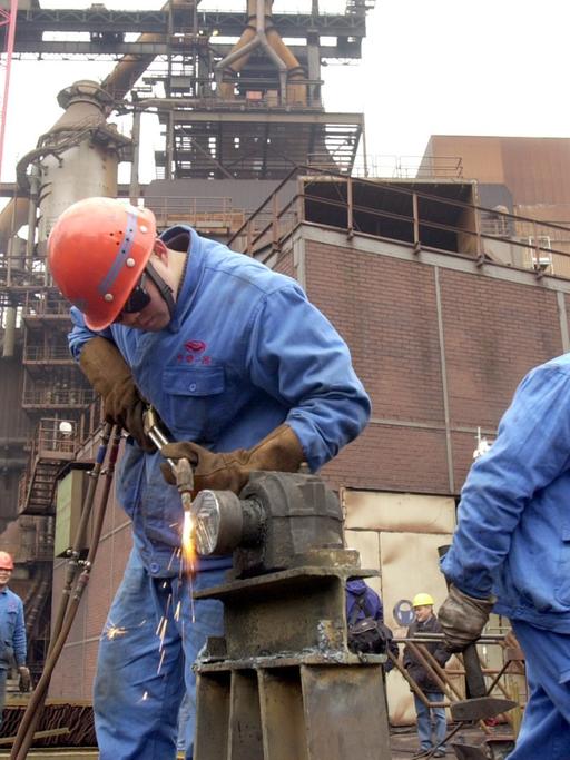 Chinesische Fachkräfte sind am 15.03.2002 mit der Demontage der Dortmunder Westfalenhütte beschäftigt. Bis März 2004 soll erstmals ein komplettes Hüttenwerk mit einem Gesamtgewicht von 250 000 Tonnen von Dortmund nach China umgesetzt werden. Schiffsladung für Schiffsladung soll die Anlage von Rotterdam, Antwerpen, Hamburg und Bremen nach Zhangjiangang, dem Firmensitz der Jiangsu Shagang Group verlegt werden. Das "gebrauchte" Hüttenwerk kostet seine neuen Besitzer einen dreistelligen Millionenbetrag, sowie Transportkosten in vergleichbarer Höhe. Der Neuwert wird mit 2 Milliarden Euro angegeben.