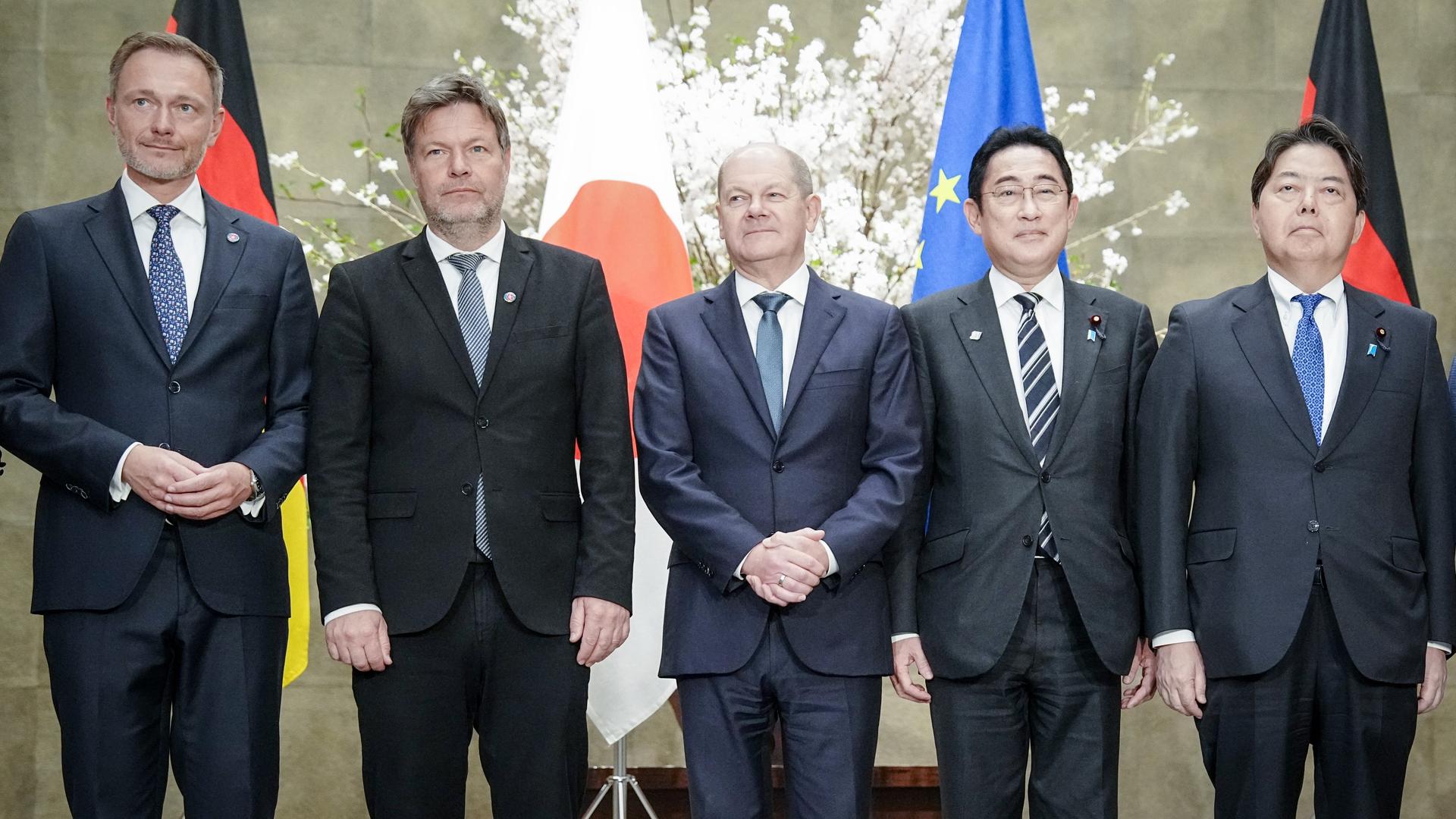 Finanzminister Christian Lindner, Wirtschaftsminister Robert Habeck und Bundeskanzler Olaf Scholz stehen neben dem japanischen Ministerpräsidenten Fumio Kishida und Außenminister Yoshimasa Hayashi vor einer japanischen, einer deutschen und einer europäischen Flagge.