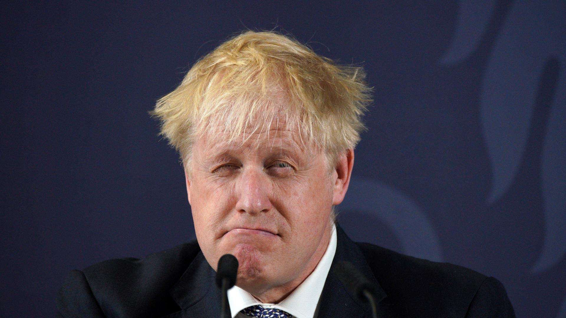 Der britische Premier Boris Johnson zieht eine Grimasse am Rednerpult. Der britische Premier Boris Johnson zieht eine Grimasse am Rednerpult.