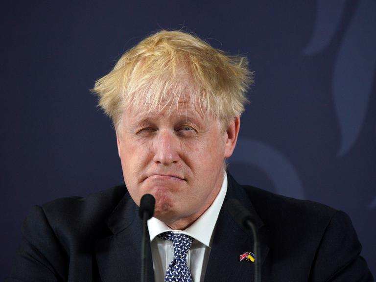 Der britische Premier Boris Johnson zieht eine Grimasse am Rednerpult.